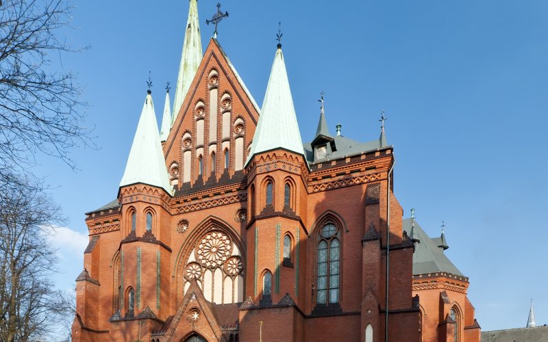 Zabytkowy kompleks budynków otoczony parkiem widziany z lotu ptaka